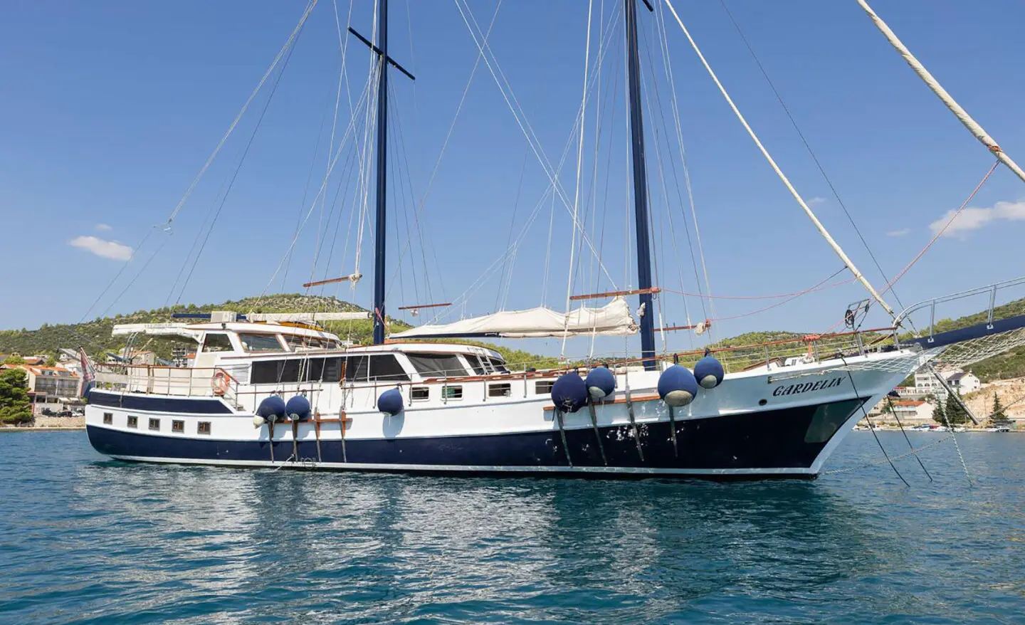 Gardelin luxury gulet at sunset, white hull, deck seating, masts tall, calm sea