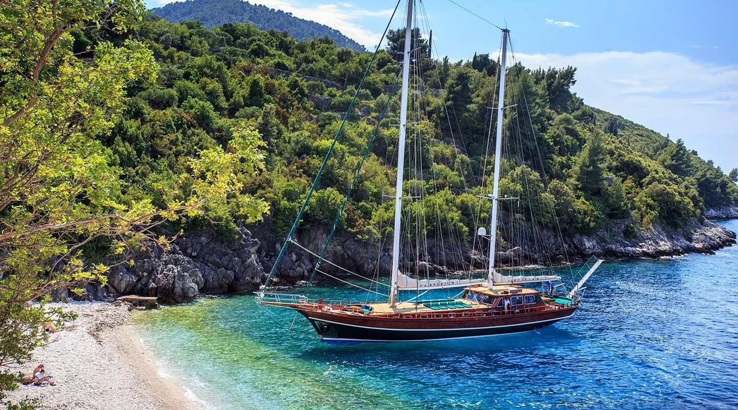 Carpe Diem 7 yacht anchored near lush green coastline at sunset