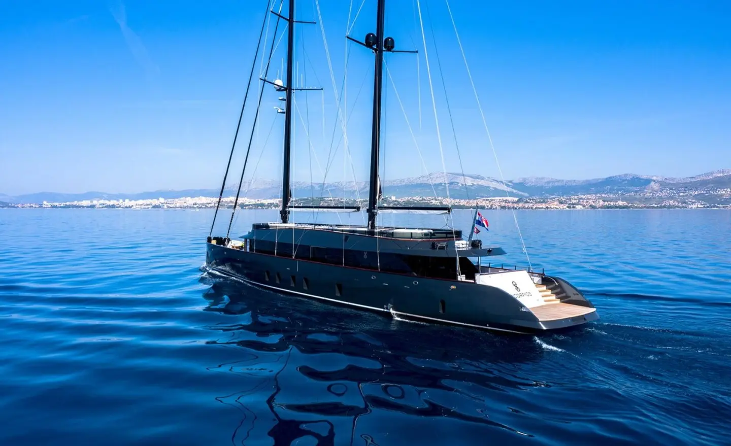Luxurious Scorpios sailing yacht anchored on calm blue sea with sails lowered