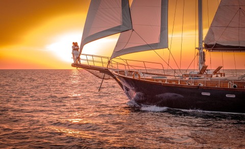 Smart Spirit sailing at sunset with two passengers on the bow lookout