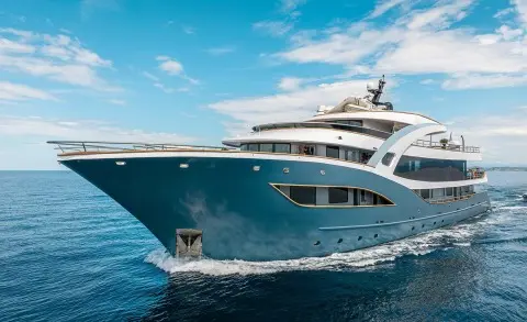 Bella motor yacht anchored with blue sea, clear sky, and hull close up