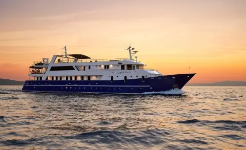 Lupus Mare luxury yacht cruising at sunset with blue hull and white superstructure