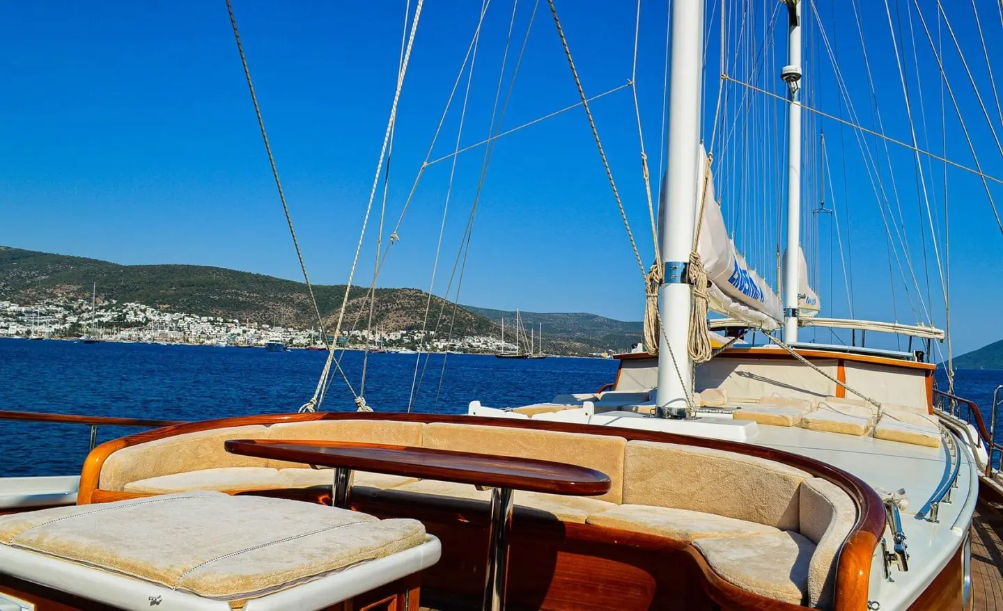 Bow deck of Enderim A gulet with wooden seating and blue rigging against sea