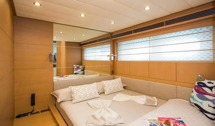 Salt yacht cabin interior with a large bed, wooden panels, and windows