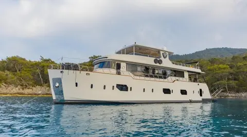 Luxury Simay M yacht anchored with white hull and multiple decks on blue water