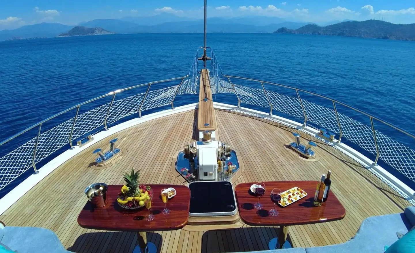 Top-down view of Maya yacht bow with seating area and calm sea horizon