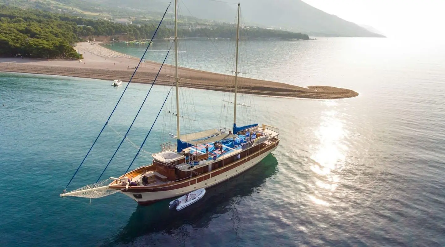 Luxurious sailing yacht Tajna Mora moored at sunset on calm turquoise waters