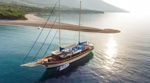 Luxurious sailing yacht Tajna Mora moored at sunset on calm turquoise waters