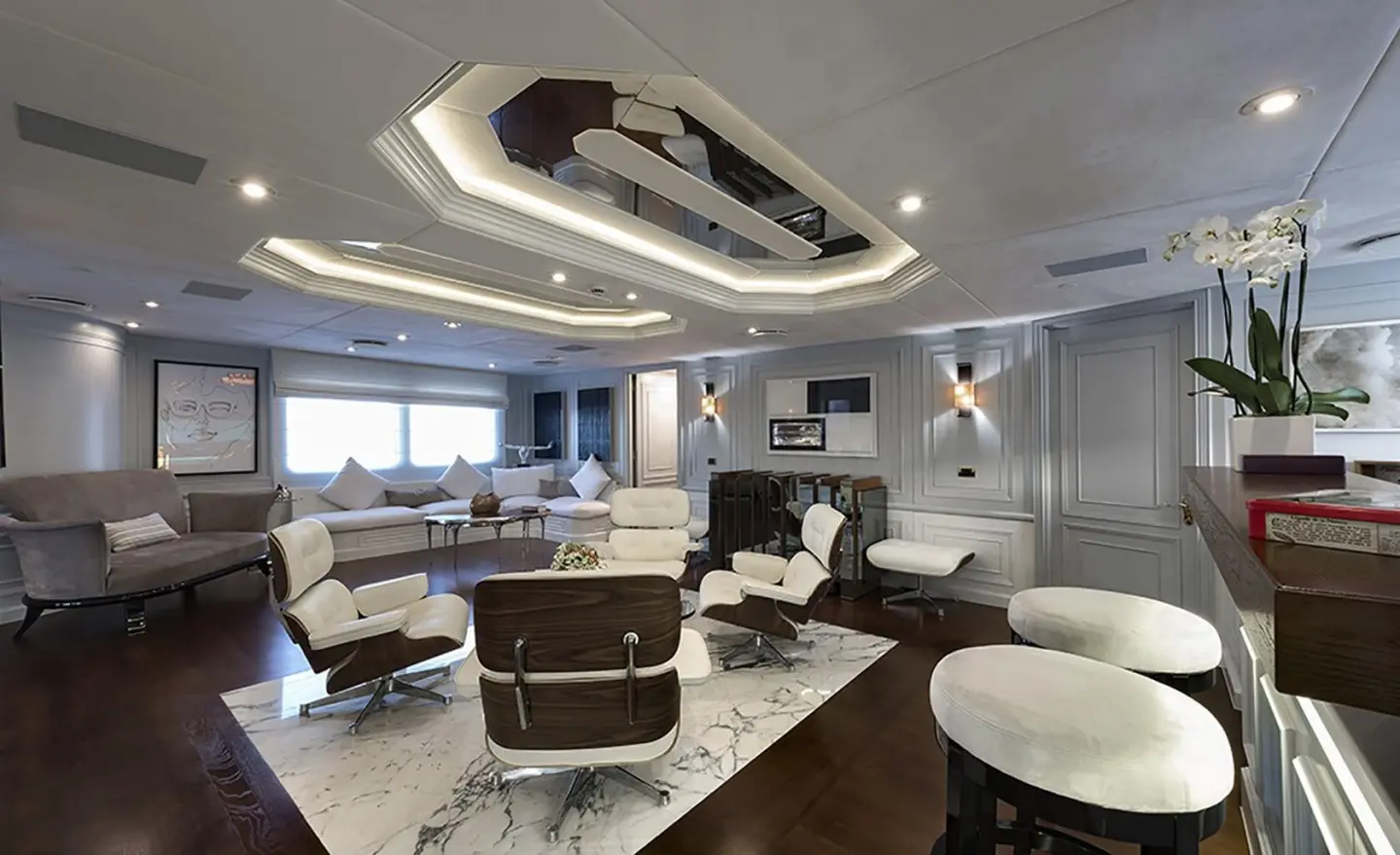 Interior lounge area of Chakra yacht with seating, coffee table, and large windows