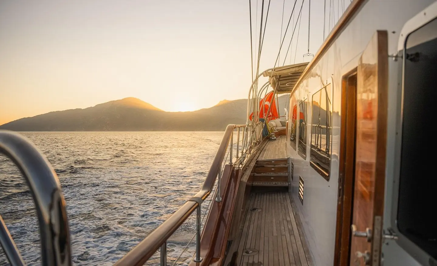 Gulet La Bella Vita deck at sunset with railing and passengers on port side