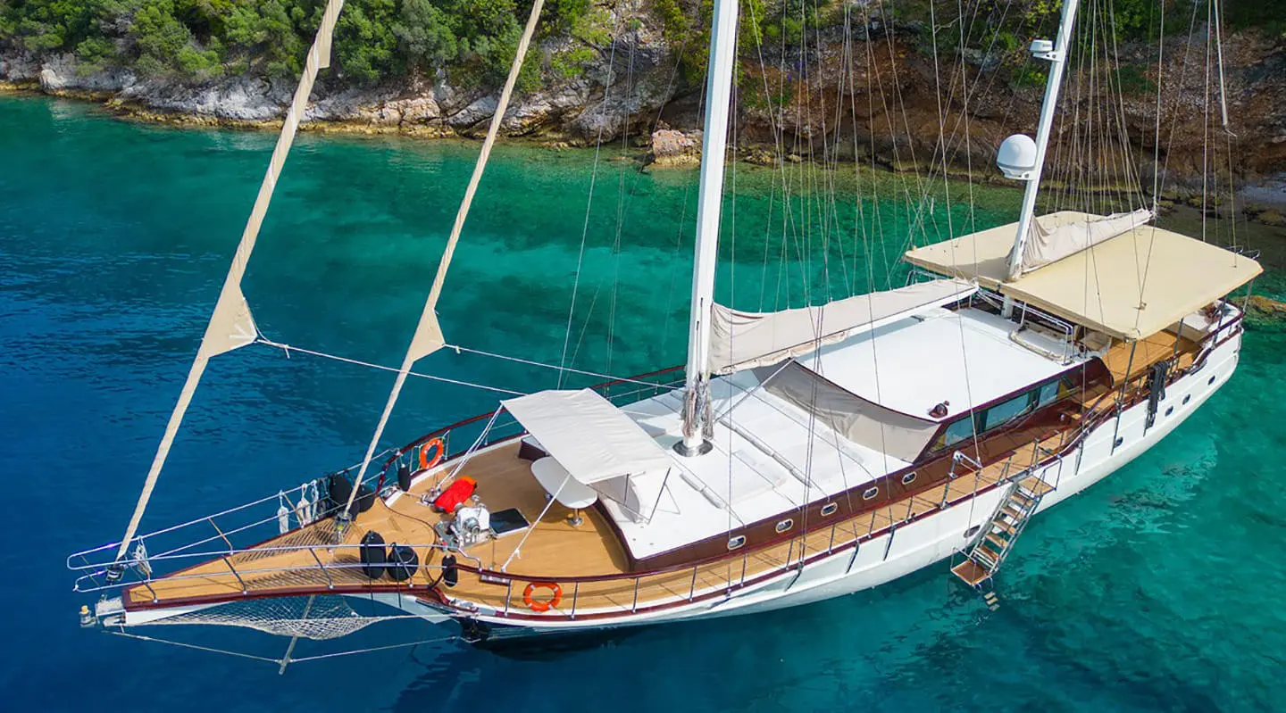 Mein Schatz yacht anchored near turquoise water with white sails and deck seating