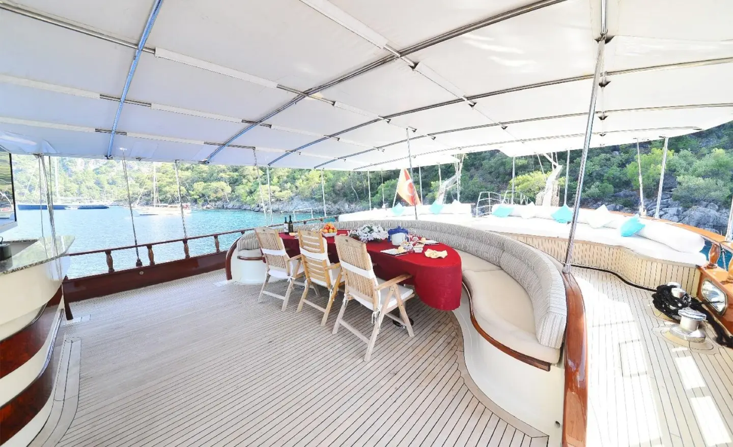 Yacht Berrak Su deck area with seating and sunshades at sunset harbor