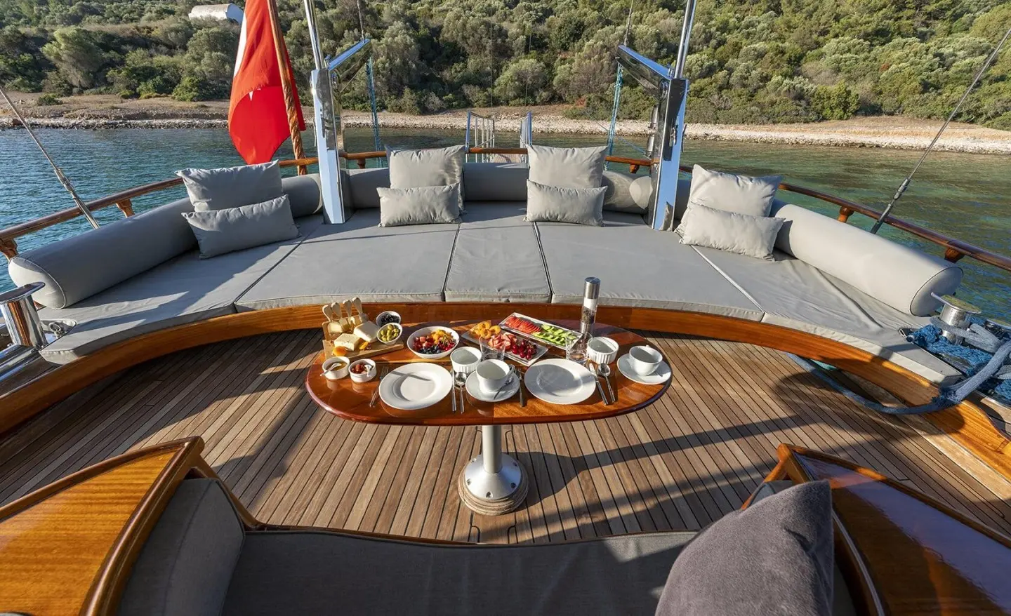 Deck on a luxury gulet with sunbathing area and a table set for meals