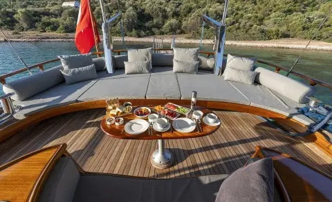 Deck on a luxury gulet with sunbathing area and a table set for meals