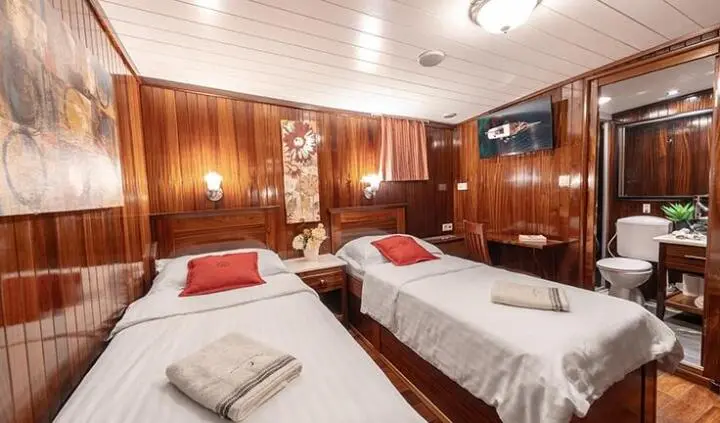 Twin cabin interior on Cesarica yacht with wood paneling and two beds