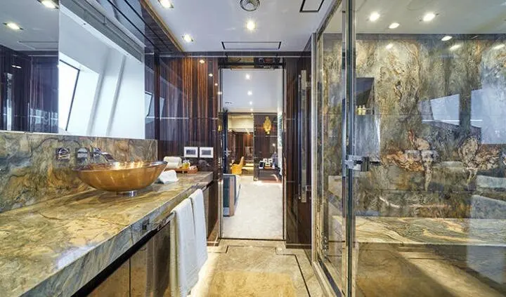 Luxurious master cabin with king bed, wood panels, and ensuite bath