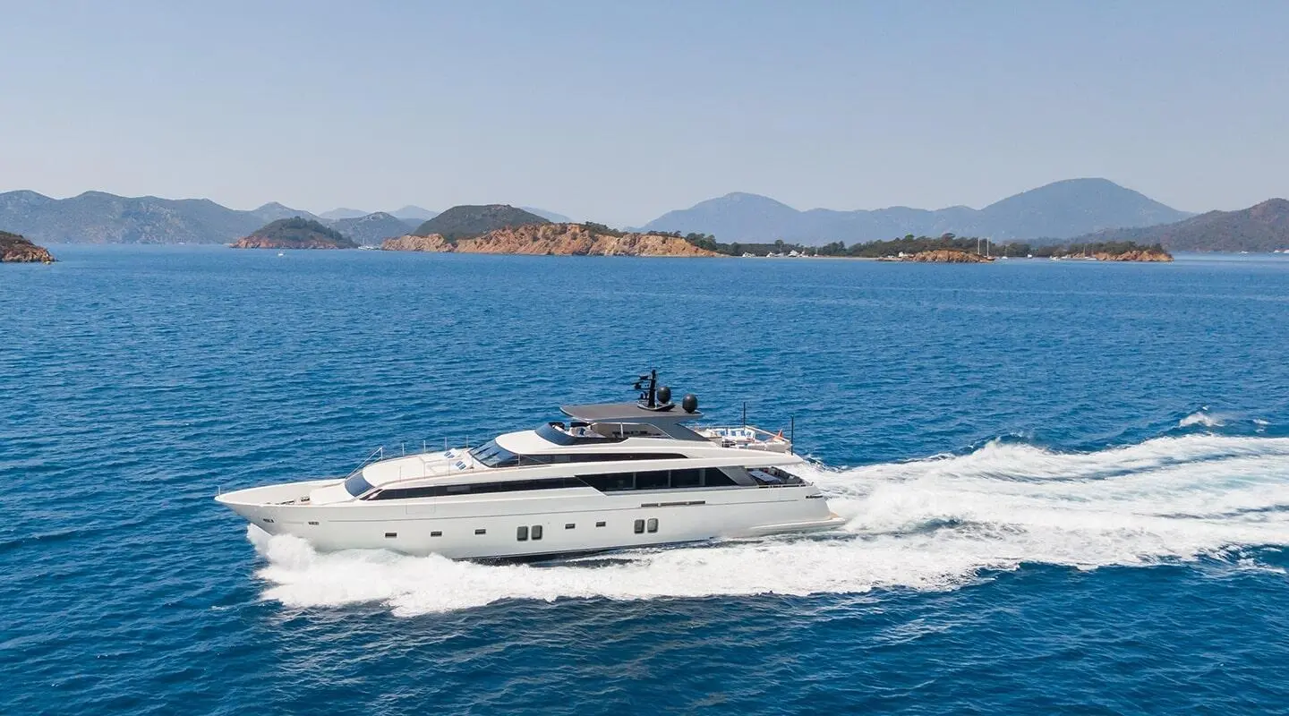 Morning Star yacht cruising calm blue sea with distant rocky hills