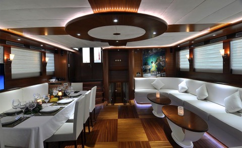 Dolce Mare interior: elegant dining and lounge with white upholstery and wood paneling