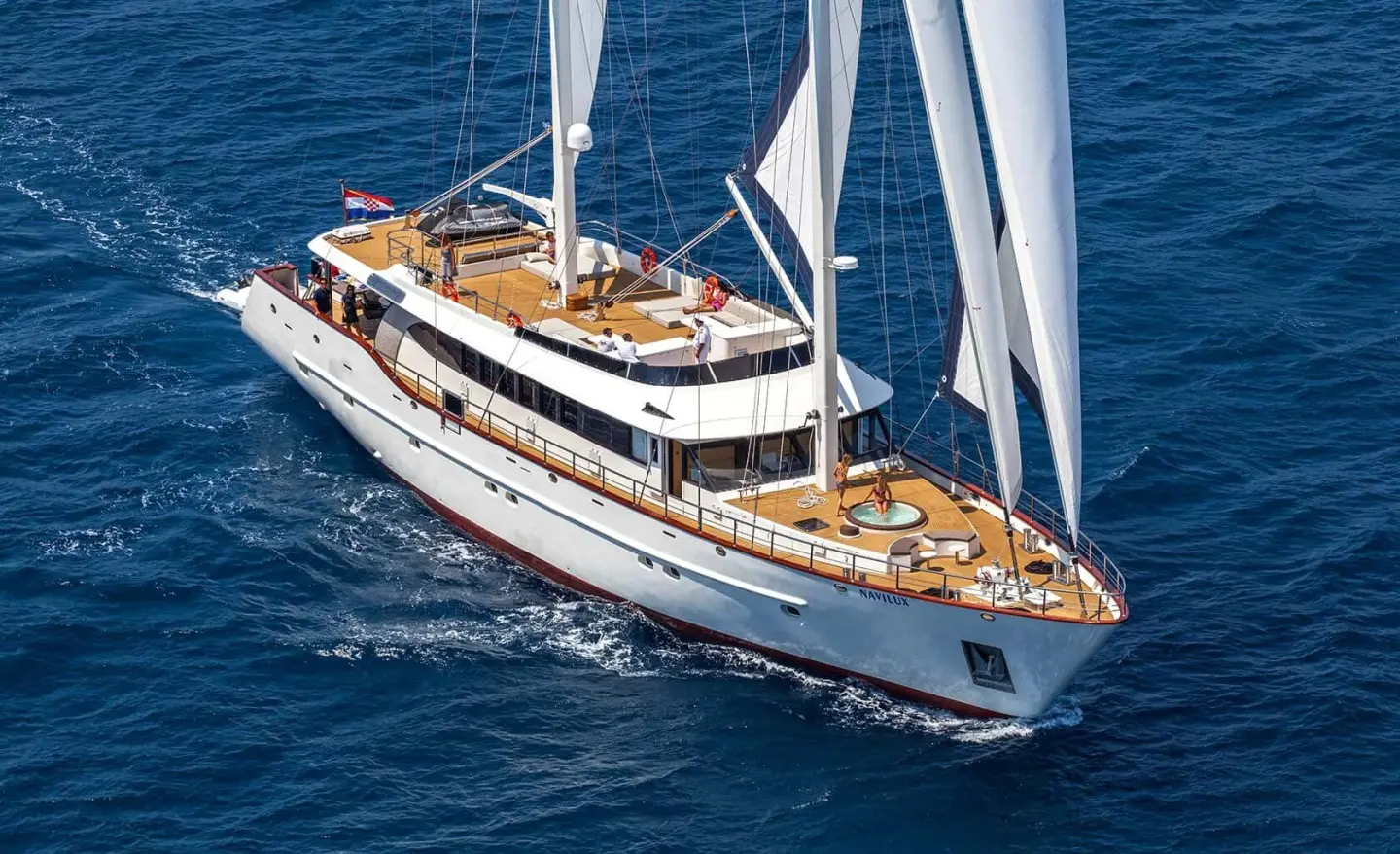 Navilux yacht on open sea, deck with sunbathing area and jacuzzi visible