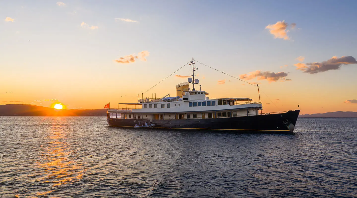 Seagull II luxury yacht anchored at sunset with warm glow on the water