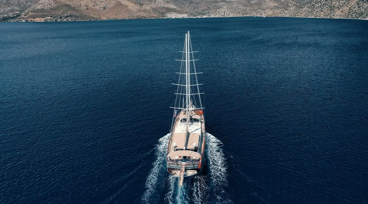 Aerial view of Nevra Queen yacht sailing on calm blue sea at dusk