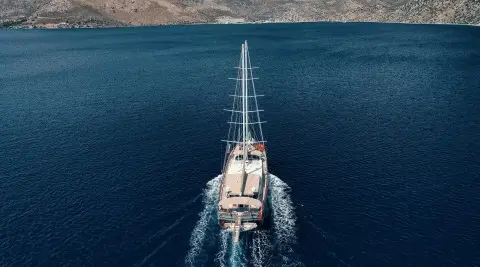Aerial view of Nevra Queen yacht sailing on calm blue sea at dusk