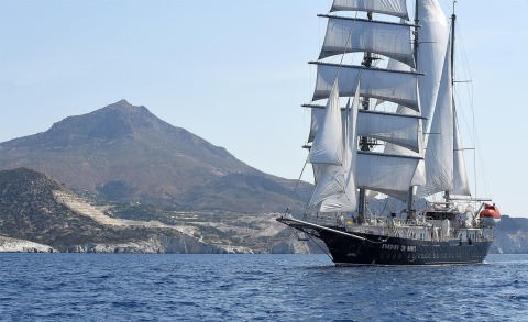 64m luxury sailing yacht Running on Waves cruising near rocky coastline