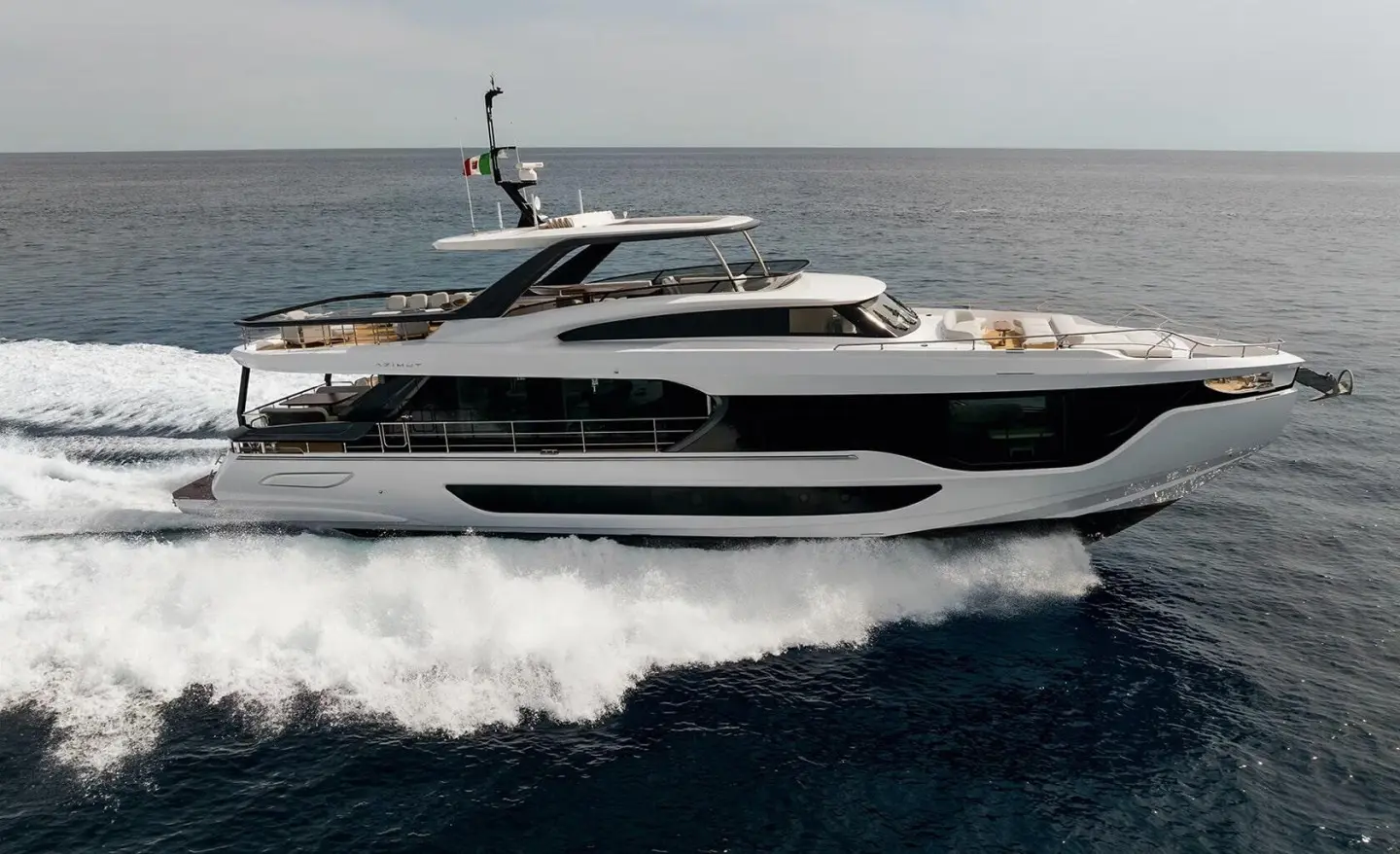 Viva II motor yacht cruising water with wake, side view on blue sea