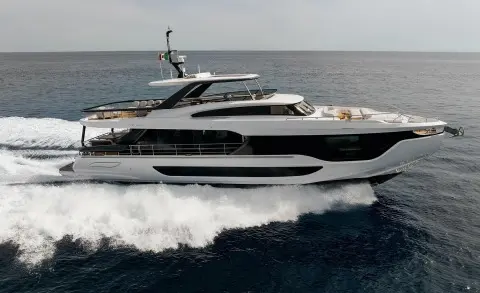 Viva II motor yacht cruising water with wake, side view on blue sea