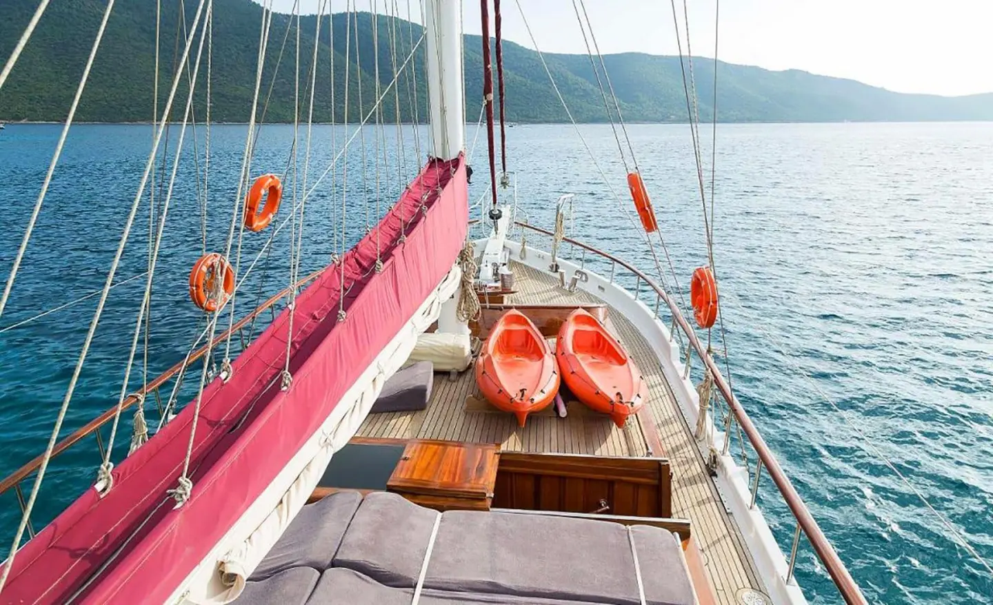 Yacht Primadonna on calm sea, sun deck view with orange lifebuoys and red cushions