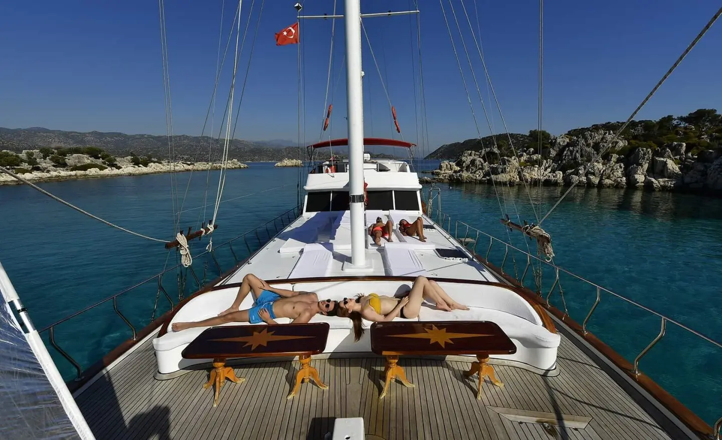 Blu Dream yacht deck with sun loungers facing calm blue sea at sunset