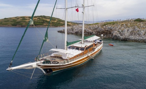Ecce Navigo gulet yacht anchored in calm water with wooden hull