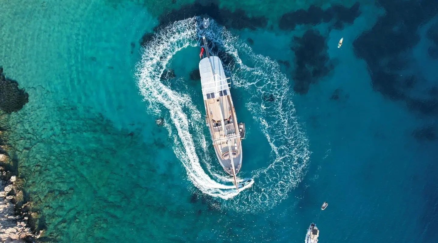 Aerial view of Arif Kaptan A yacht cruising blue-green waters at sunset