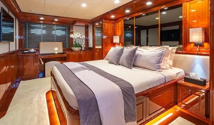 Divine cabin aboard yacht with king bed, wood paneling, dual bedside lamps