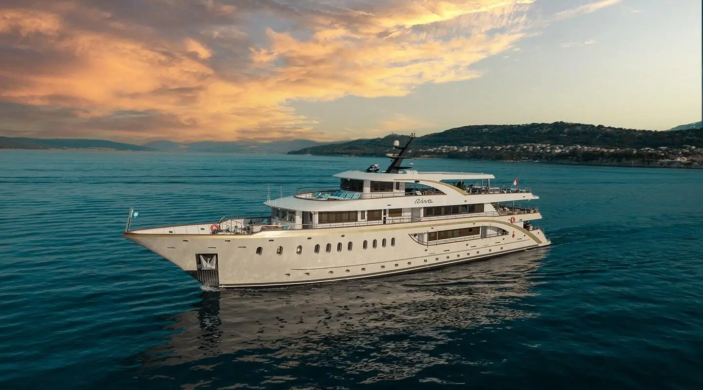 Luxurious Riva motor yacht cruising calm blue waters at sunset