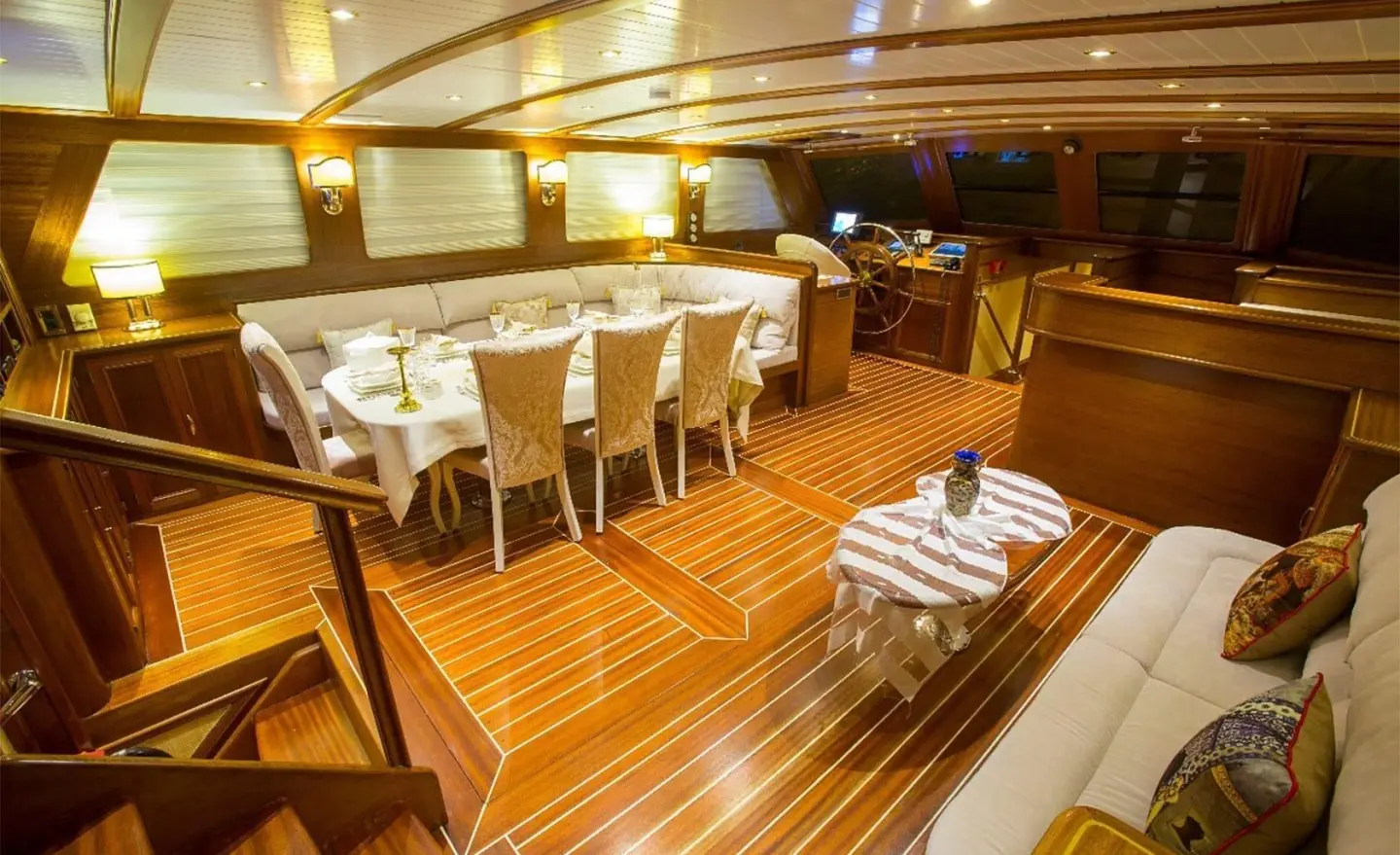 Luxurious yacht Ece Berrak interior with wooden deck and dining area at dusk