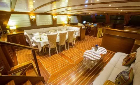 Luxurious yacht Ece Berrak interior with wooden deck and dining area at dusk