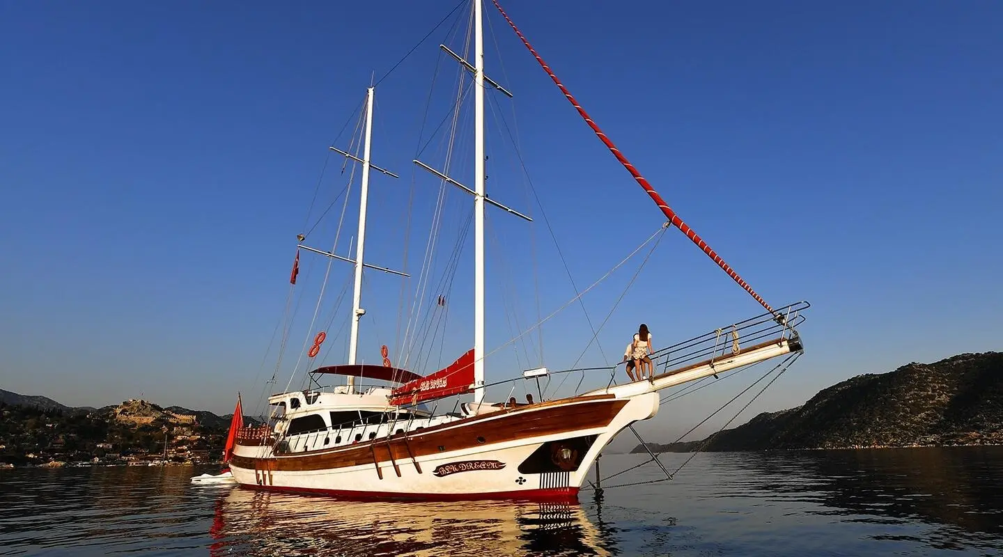 Blu Dream yacht anchored in calm water with its stern and sails visible