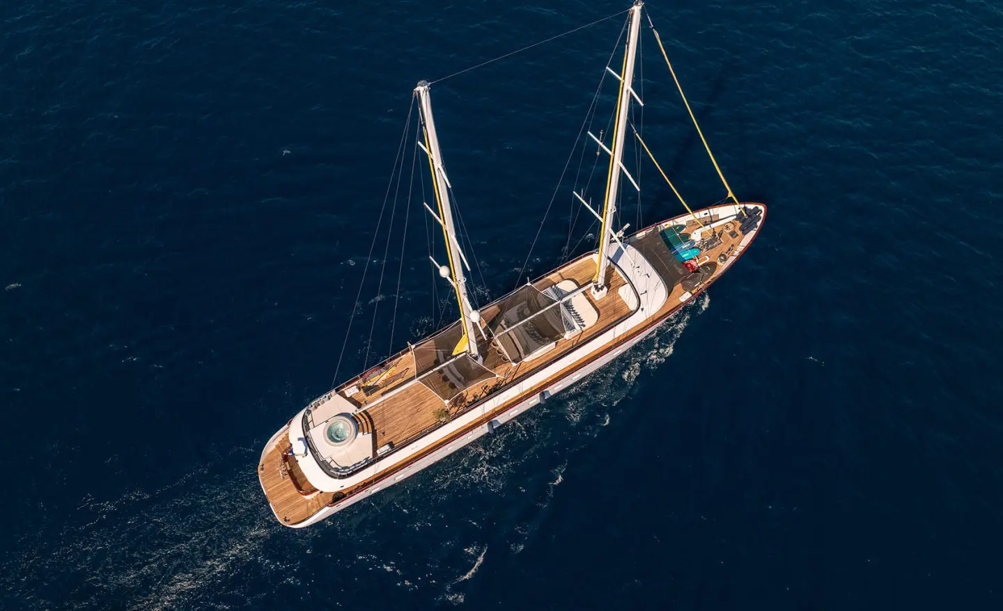 A luxury sailing yacht Anima Maris viewed from above at sea, sunlit deck