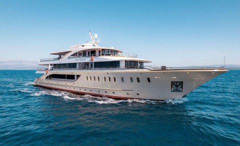 A luxury 49m yacht sailing on blue sea under bright sky