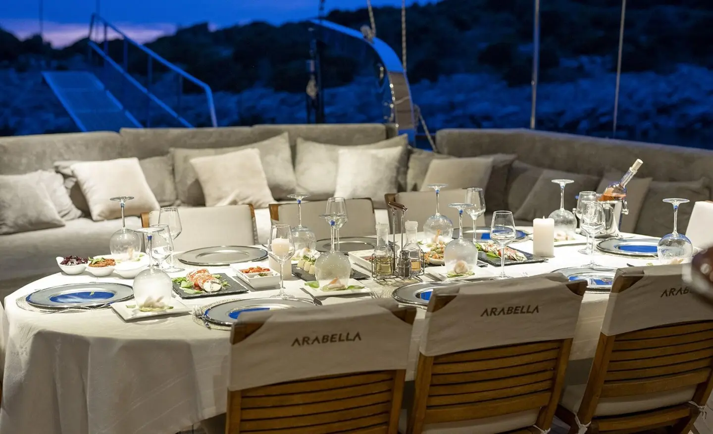 Arabella luxury gulet dining setup on deck with plates and glasses