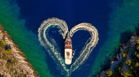 Aerial view of gulet Cesarica yacht at sea with a V-shaped wake