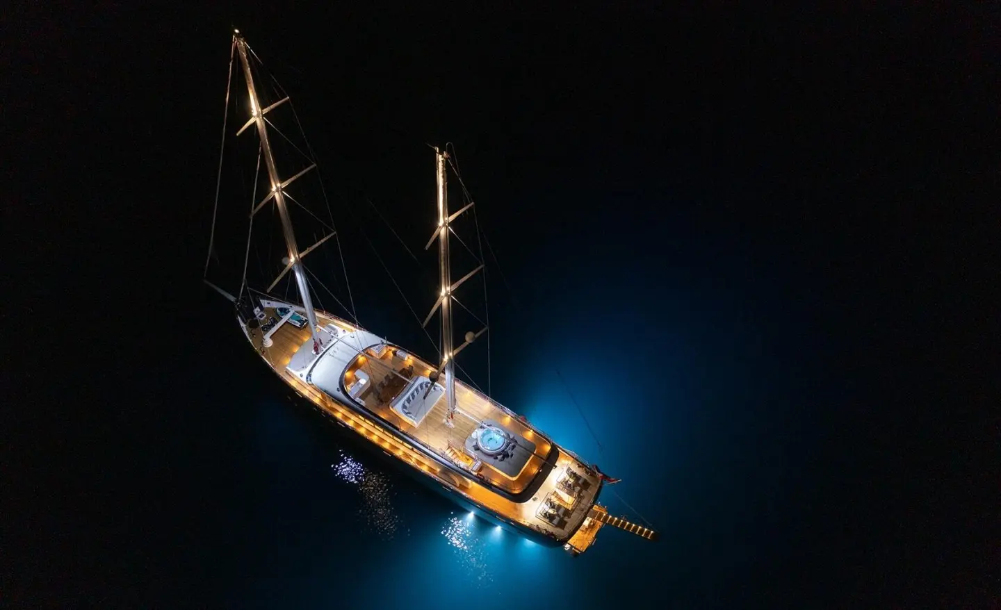 Luxury sailing yacht Love Story at night, illuminated hull on dark sea