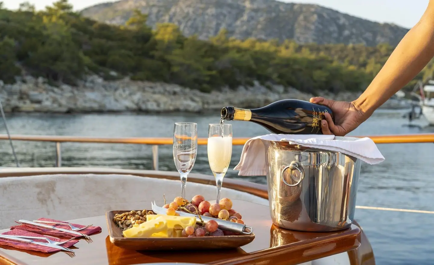 Artemis gulet yacht on calm water with champagne glasses and snacks on deck