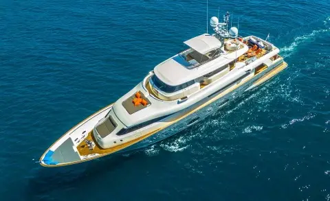 A sleek luxury yacht named Seventh Sense sails on blue sea, white hull
