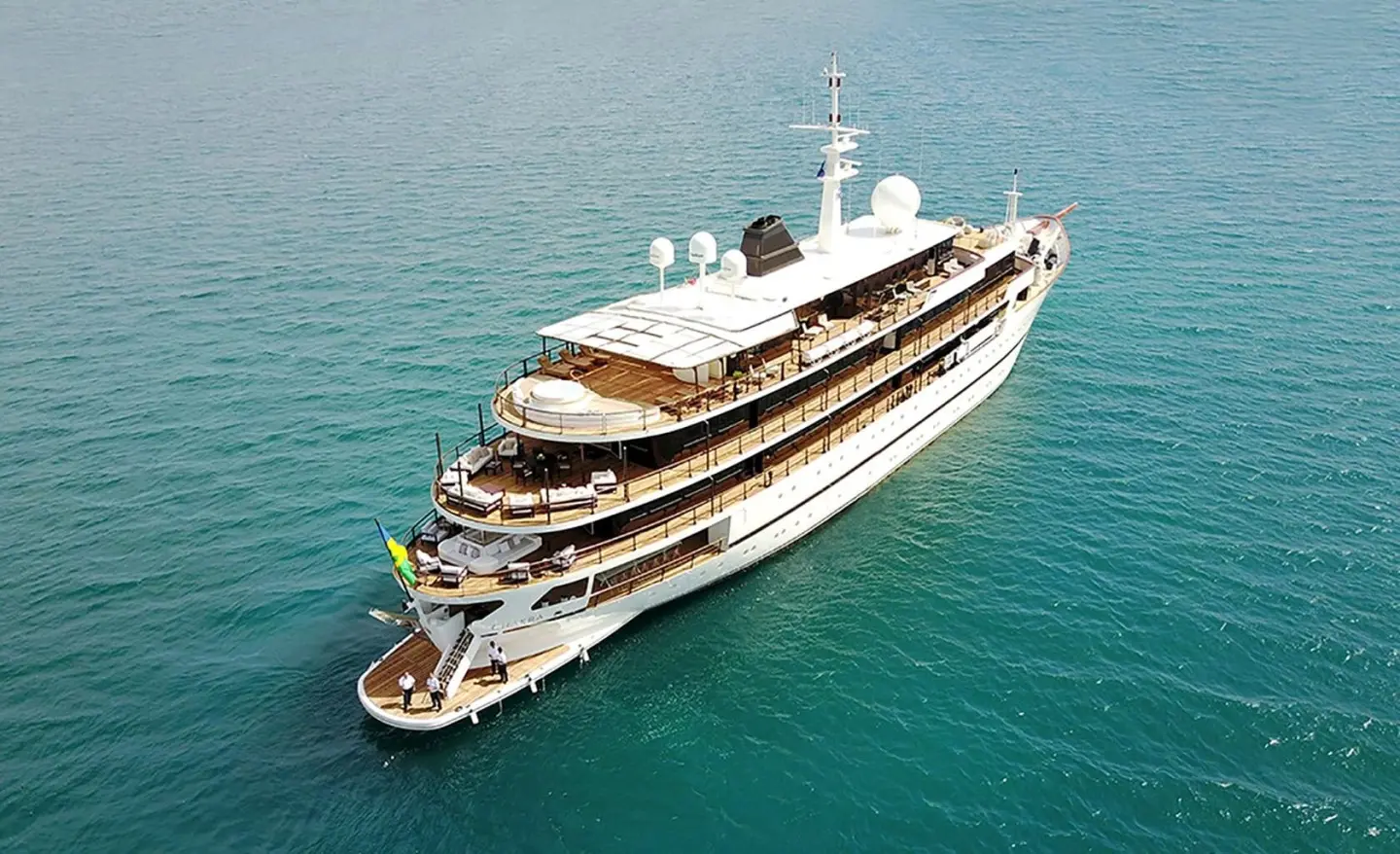 Overhead view of a multi-deck luxury motor yacht named Chakra anchored in clear blue water