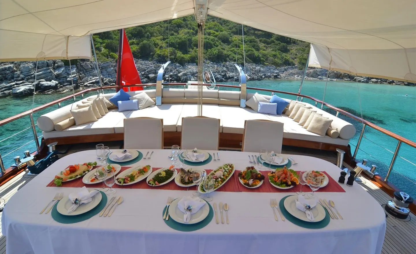 Aft deck of Blue Heaven gulet with sun cushions, tableware, and shaded seating