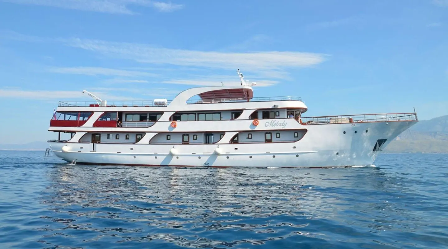 Melody motor yacht cruising on calm blue water, white hull, clear sky