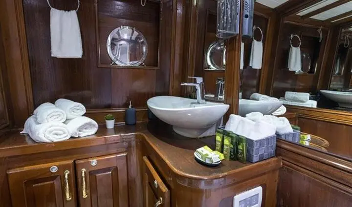 Master cabin onboard Grace 1 yacht with king bed, ensuite and stacked towels