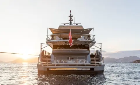 Illusion II luxury motor yacht at sunset, rear view on calm water